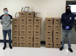 two people standing next to stacked boxes