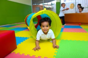 Child playing on a colorful floor mat
