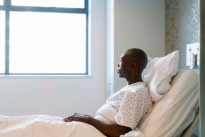 Thoughtful mid-adult male patient lying in bed.